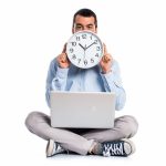 man-with-laptop-holding-watch_1368-5070