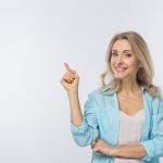 smiling-young-woman-pointing-her-finger-against-white-background_23-2148029502