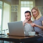 couple-sitting-table-using-laptop_1170-533