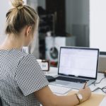 rear-view-businesswoman-writing-notes-brown-paper-with-laptop-desk_23-2147955185