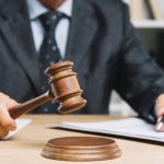 close-up-de-juiz-dar-veredicto-batendo-mallet-escrivaninha_23-2147898256