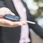 Man is giving a car key to somebody
