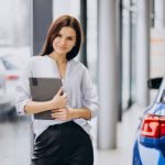 jovem-mulher-em-um-showroom-de-carro-escolhendo-um-carro_1303-19779