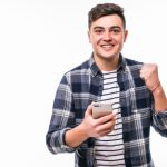 cara-jovem-sorridente-esta-comemorando-a-vitoria-de-seu-time-favorito_231208-2282