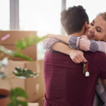 Happy couple with keys of new apartment